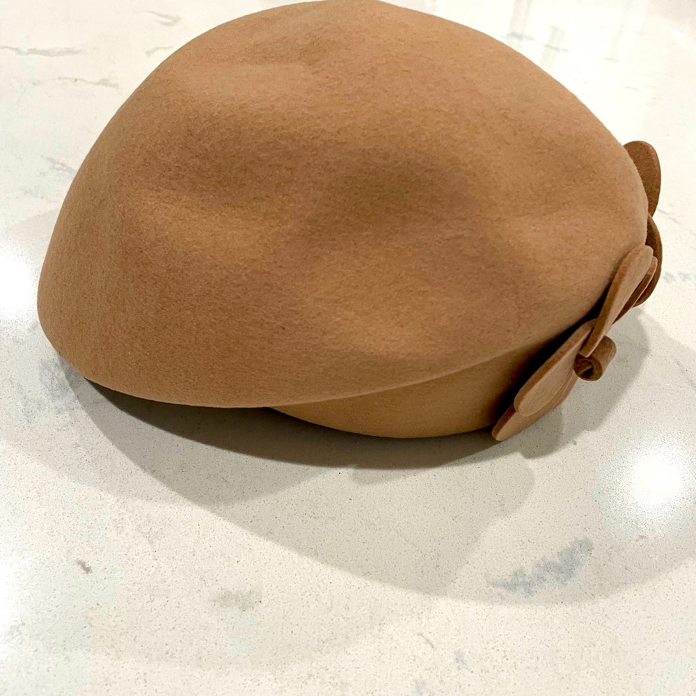 Fashionable tan beret with attached flower.